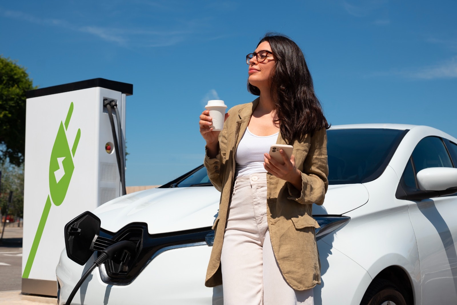 Woman at an EV charging station with electric vehicle